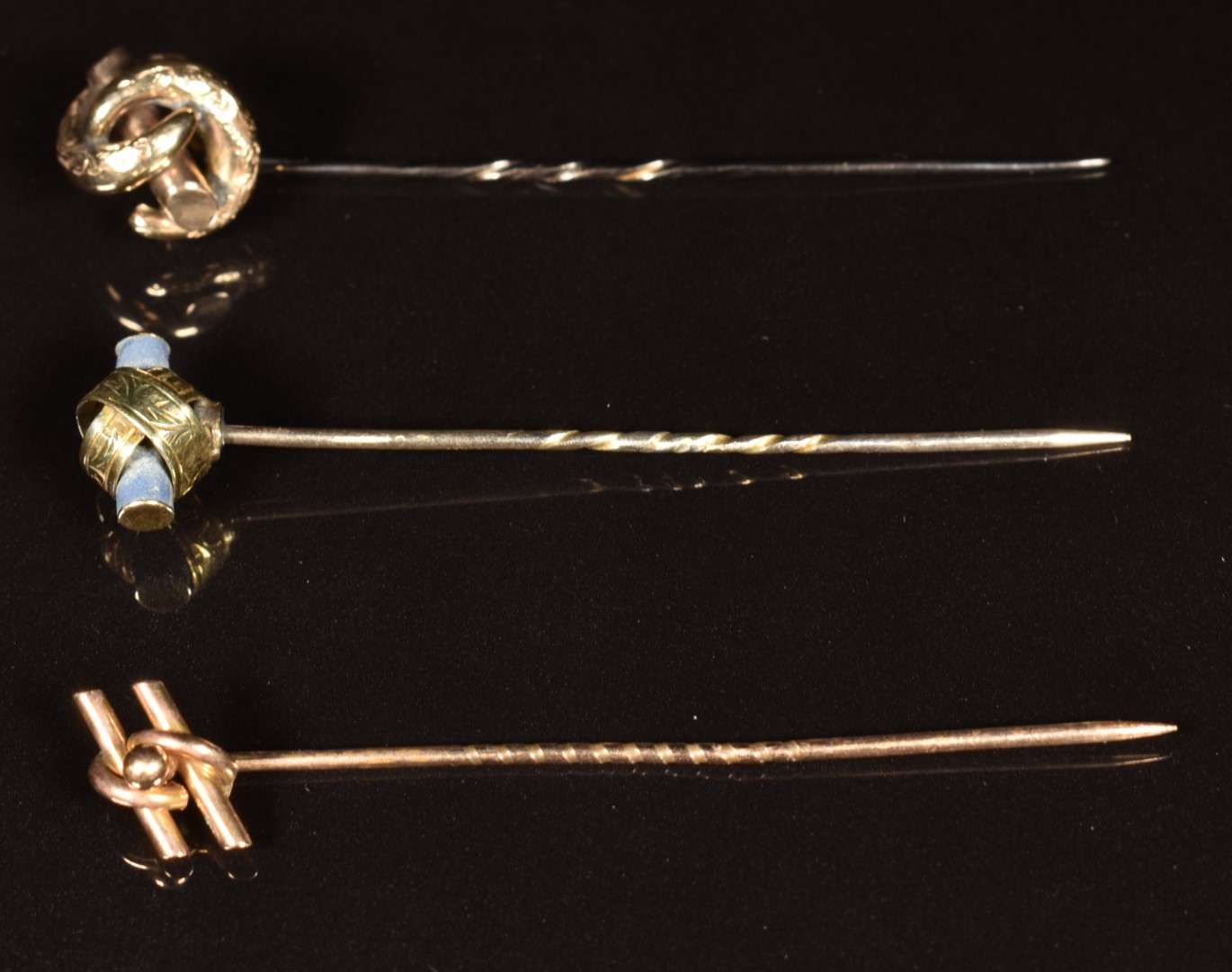 Edwardian 15ct gold stick pin (1.2g) and two yellow metal knot stick pins with engraved decoration