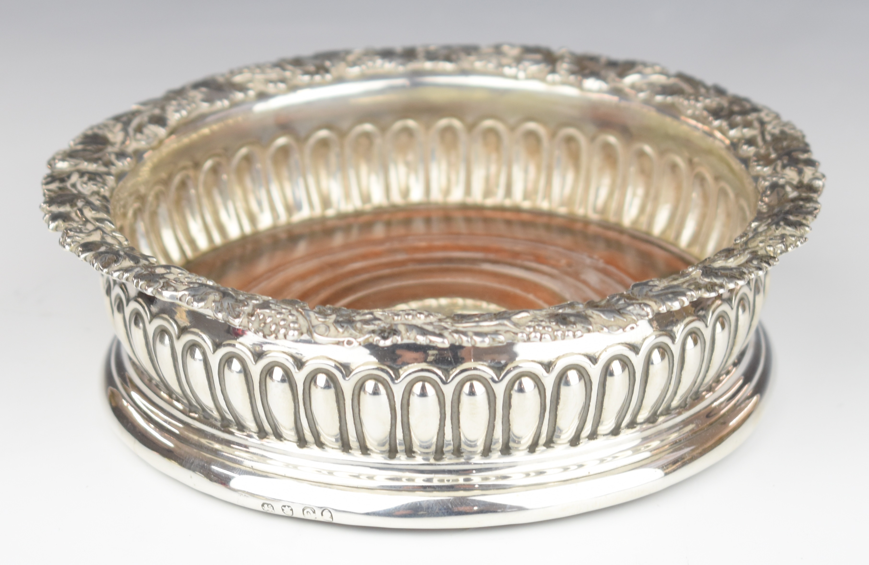 Georgian hallmarked silver wine coaster with reeded body and grape vine rim, London circa 1820 but