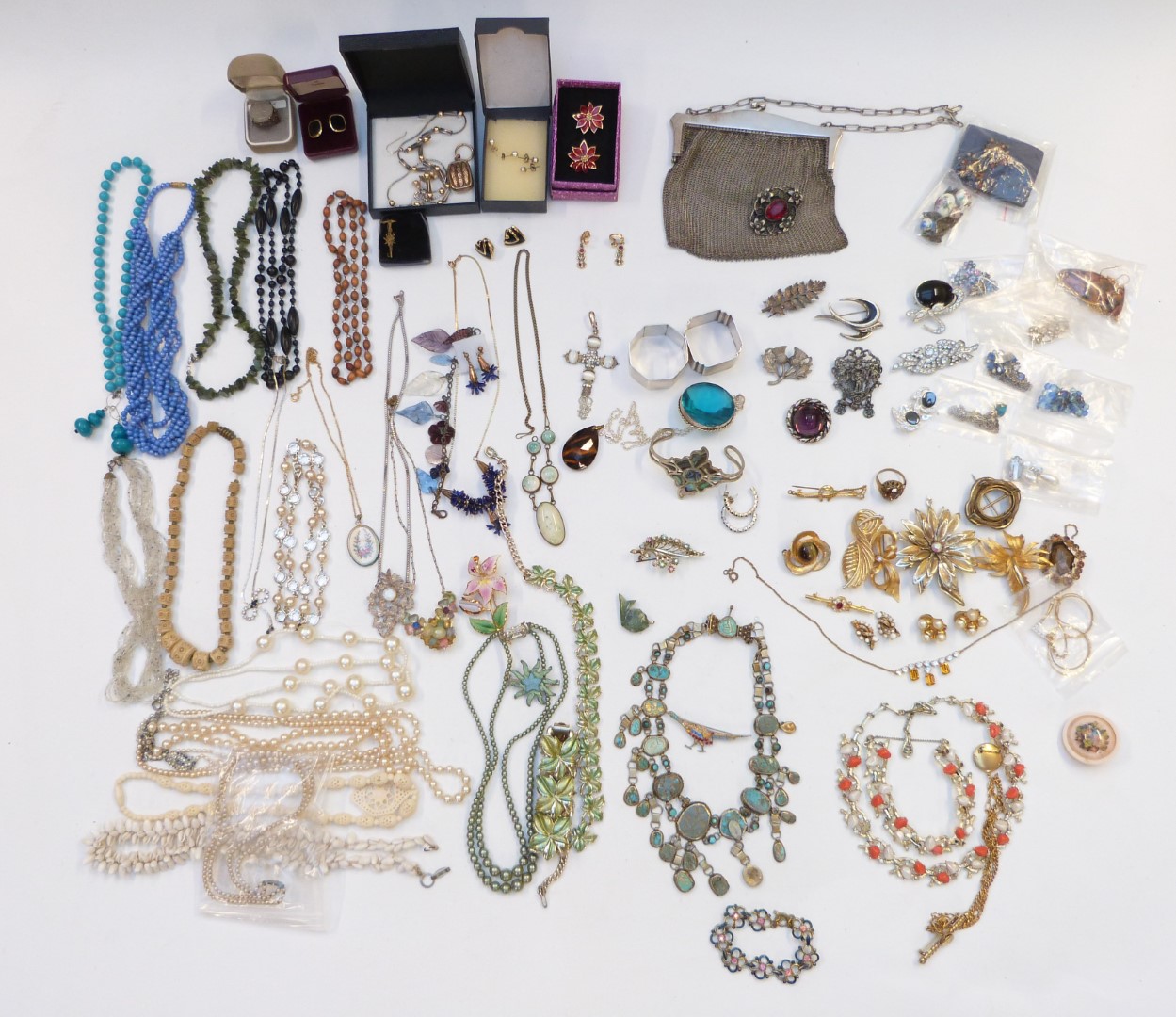 A collection of costume jewellery including two silver napkin rings, costume brooches, beads,