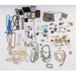 A collection of costume jewellery including two silver napkin rings, costume brooches, beads,