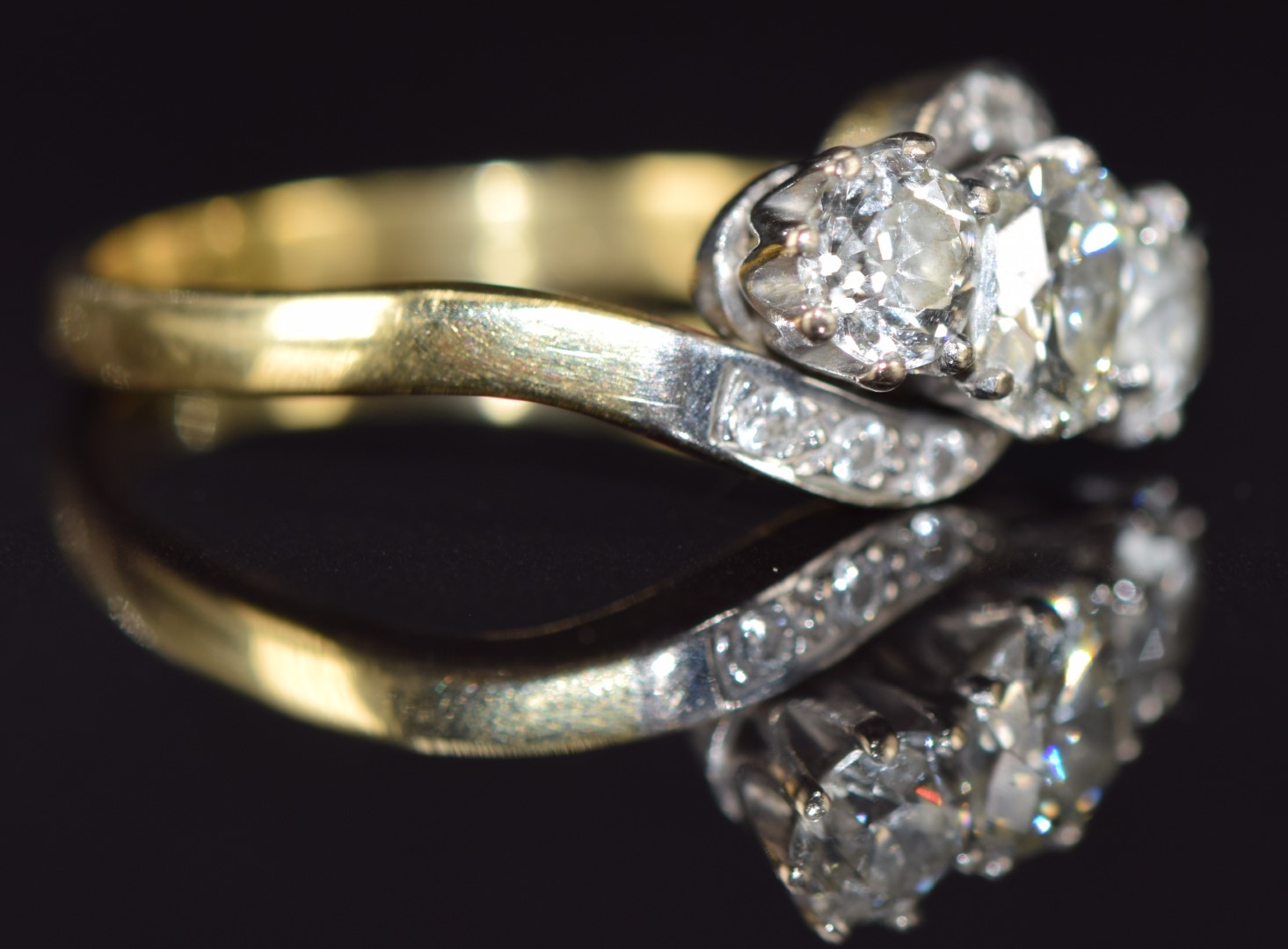 An 18ct gold ring set with three old cut diamonds in a twist setting, the centre diamond - Image 2 of 2