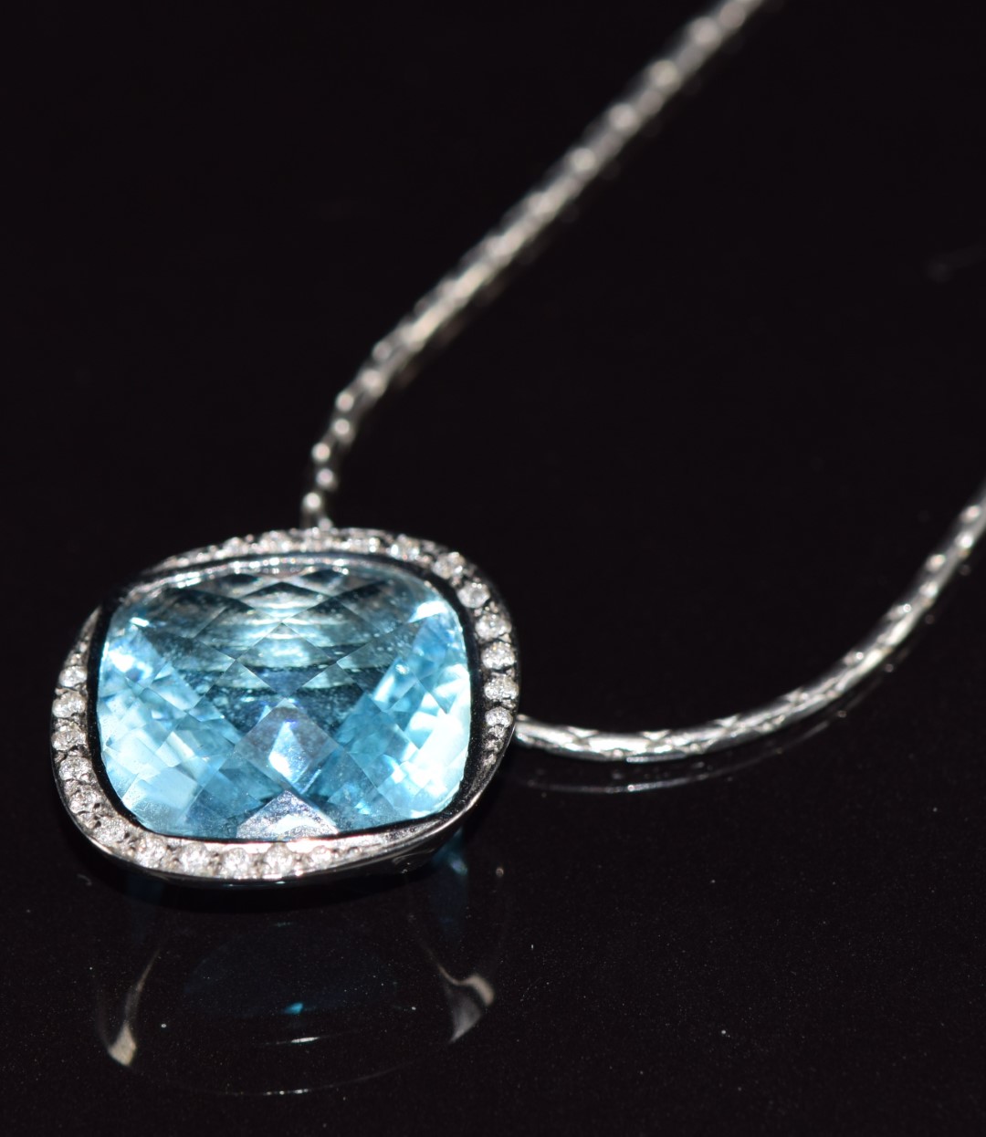 An 18ct white gold pendant set with a blue topaz and diamonds, on 18ct white gold chain, 15.1g