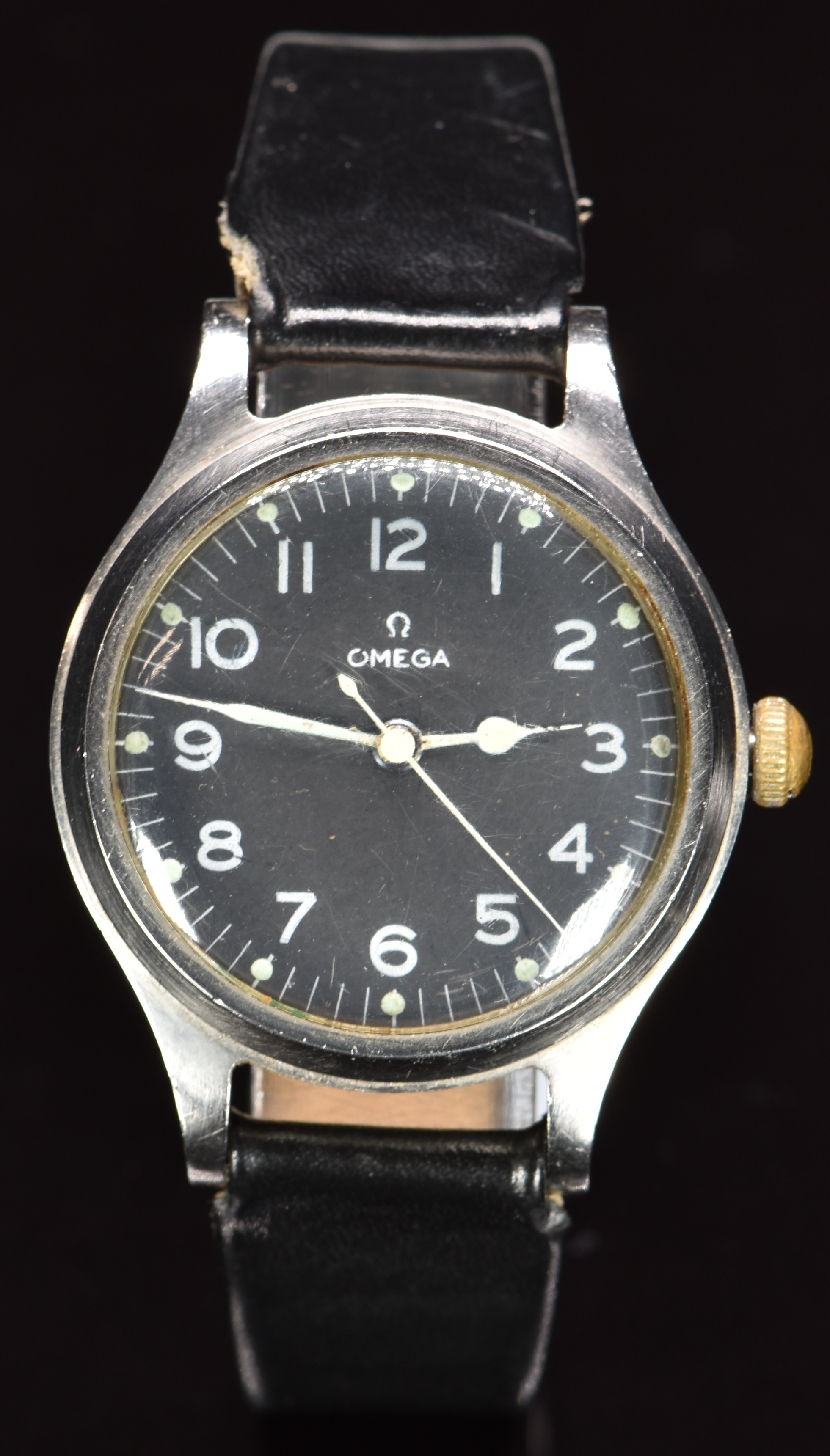 Omega British military issue wristwatch with luminous hands, white Arabic numerals, black dial,