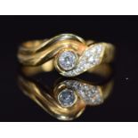 An 18ct gold ring set with diamonds in a twist setting, the largest diamond approximately 0.15ct,