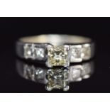 A 14ct gold ring set with a princess cut diamond of approximately 0.6ct and four further princess