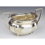 Early 20th century hallmarked silver twin handled sugar bowl with gadrooned edge, raised on four