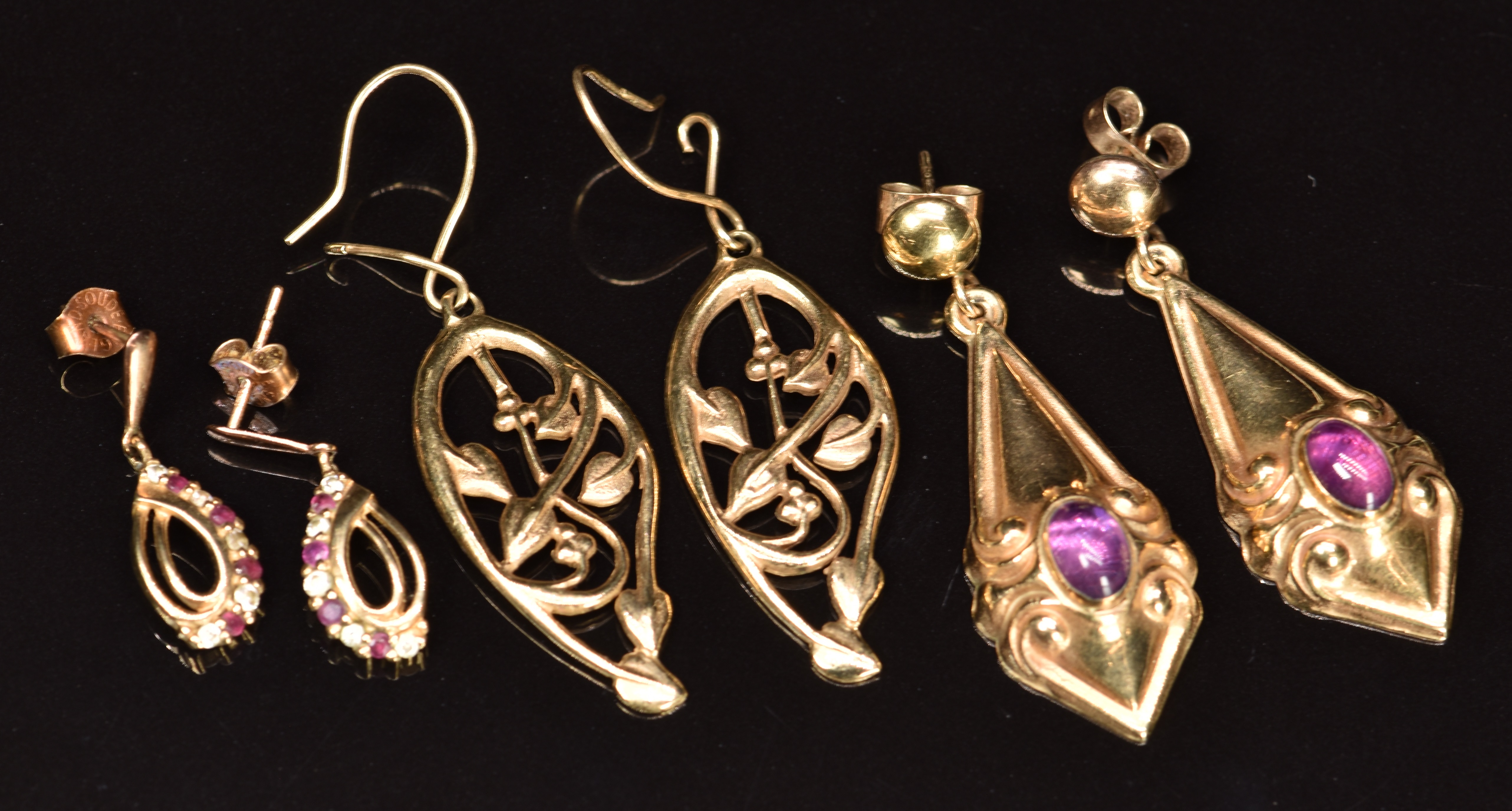 Three pairs of 9ct gold earrings, one pair set with rubies and cubic zirconia, one with amethyst and