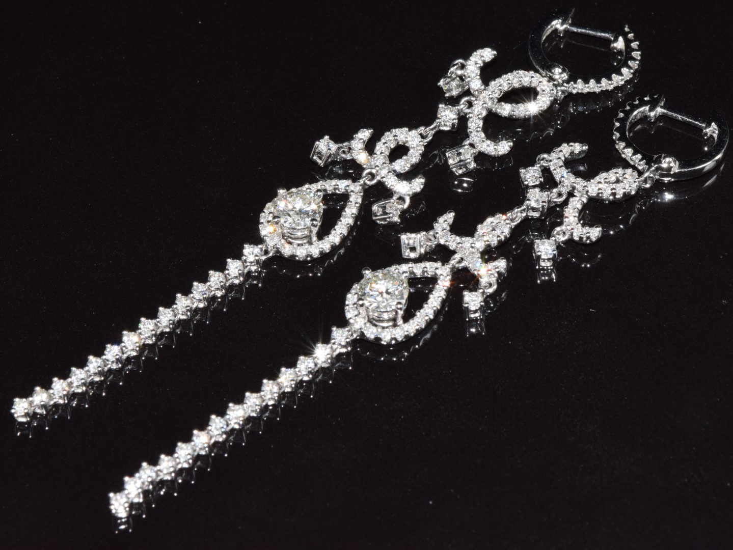 A pair of 18ct white gold earrings set with a diamond of approximately 0.4ct and a quantity of