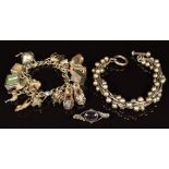 A silver charm bracelet with fifteen silver charms including Nuvo hovercraft, two banknotes,