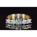 An 18ct gold ring set with five diamonds, the centre diamond approximately 0.21ct, 5.0g, size P