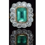 An 18ct gold ring set with an emerald cut emerald measuring approximately 1ct surrounded by 14