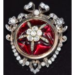 A late Victorian pendant / brooch set with garnet cabochons and old cut diamonds to the centre in