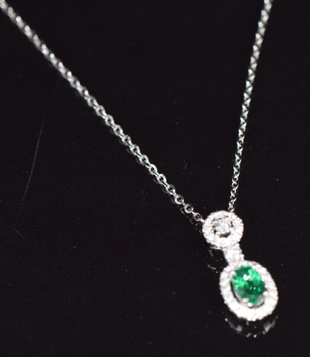 An 18ct white gold pendant set with an oval cut emerald of approximately 0.5ct surrounded by - Image 2 of 3