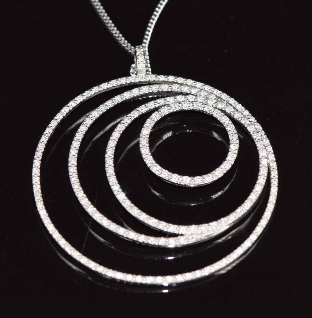 An 18ct white gold concentric circle pendant set with diamonds, on a silver chain, 16.2g