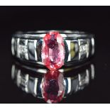 An 18ct white gold ring set with a Ceylon padparadscha sapphire and diamonds, 7.1g, size N