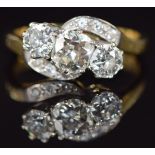 An 18ct gold ring set with three old cut diamonds in a twist setting, the centre diamond