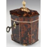 Octagonal tortoiseshell style tea caddy raised on four ball feet, height 12cm