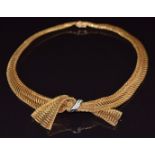 A c1960 18ct gold necklace made up of gold mesh in the form of a bow set with diamonds, 56g