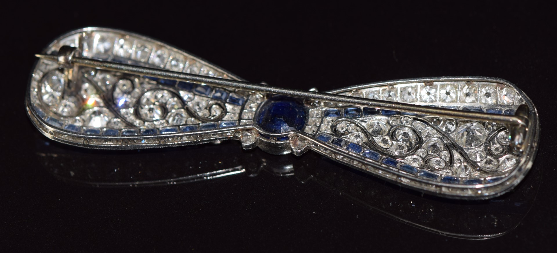 A c1915 platinum brooch in the form of a bow set with an oval cut sapphire measuring approximately - Image 3 of 7