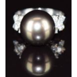 An 18ct white gold ring set with a 14ct black South Sea pearl, and with five diamonds to each