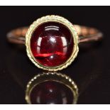 A 9ct gold ring set with a foiled garnet cabochon, 3.1g, size O