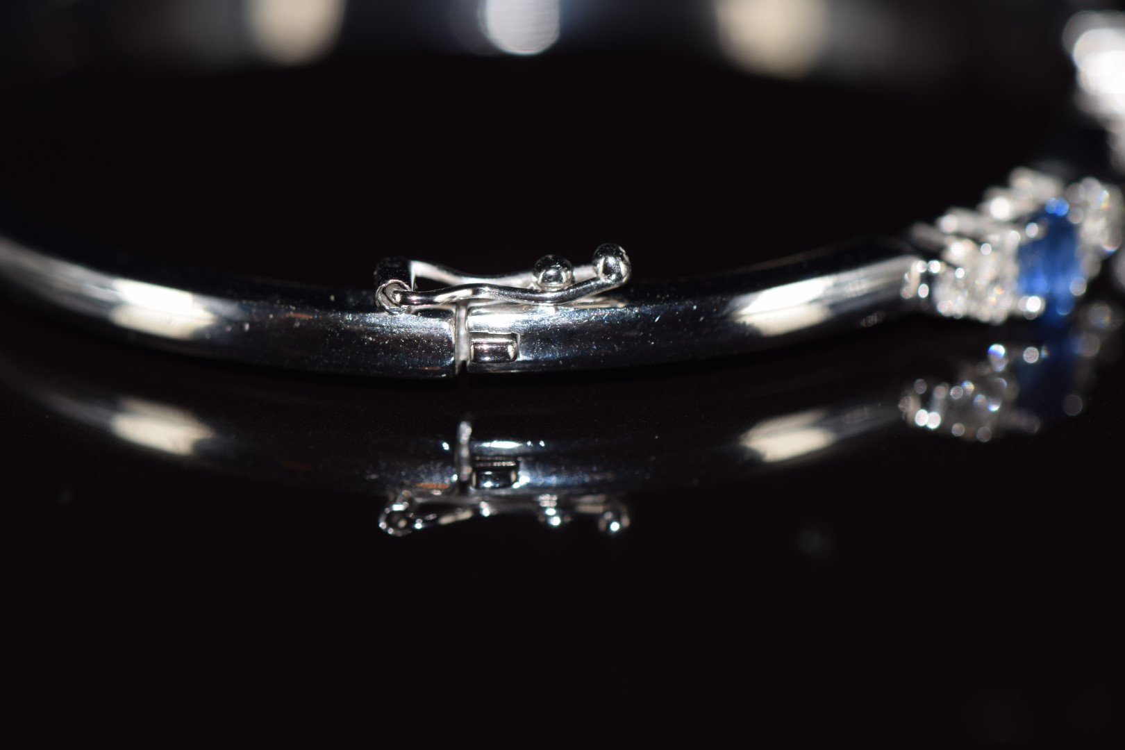 An 18ct white gold bangle set with three oval cut sapphires, each approximately 0.3ct and eighteen - Image 3 of 3