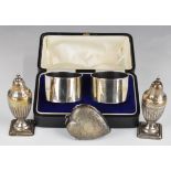 Cased pair of hallmarked silver napkin rings and a pair of hallmarked silver peppers, height 8.