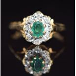 A 9ct gold ring set with an oval cut emerald surrounded by diamonds, 2g, size O