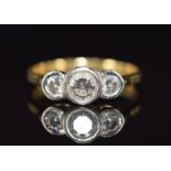 An 18ct gold ring set with three diamonds, the centre diamond approximately 0.35ct, 3.3g, size L