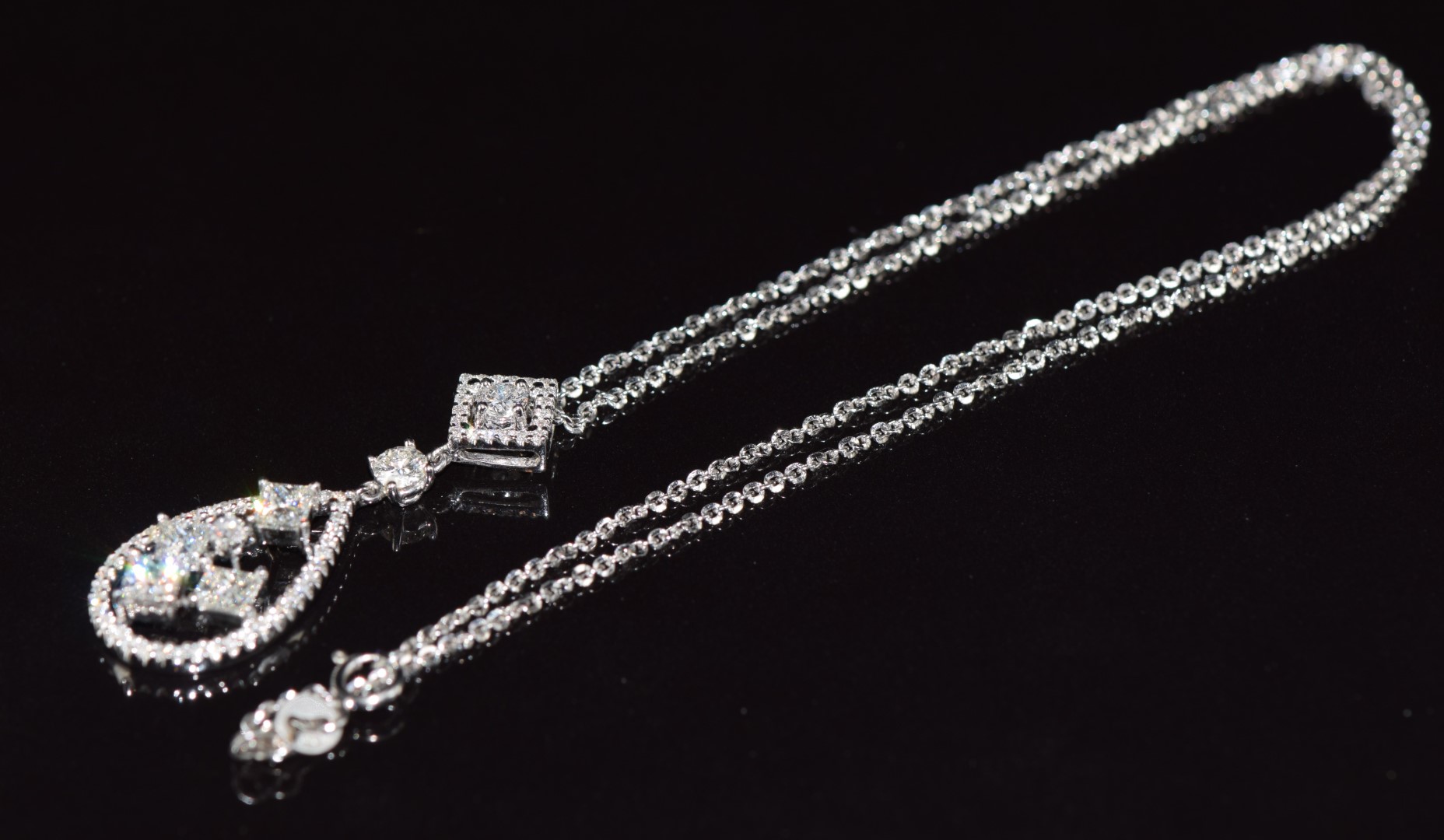 An 18ct white gold pendant set with four princess cut diamonds and further round brilliant cut - Image 3 of 3