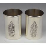 Pair of Thai silver shot measures with embossed decoration of a deity to front, marked to base