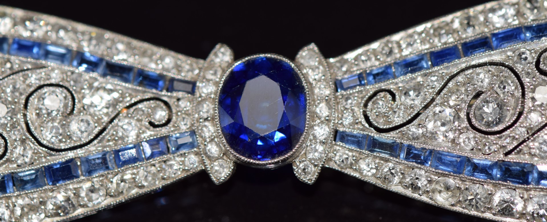 A c1915 platinum brooch in the form of a bow set with an oval cut sapphire measuring approximately - Image 5 of 7