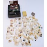 A collection of loose gemstones including moonstone cabochons, garnets, peridot, synthetic rubies,
