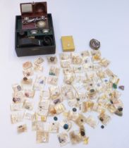 A collection of loose gemstones including moonstone cabochons, garnets, peridot, synthetic rubies,