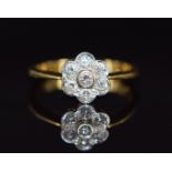 An 18ct gold ring set with seven diamonds in a floral cluster, 3.4g, size N
