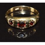A 9ct gold ring set with three garnets in star settings, 2.5g, size Q