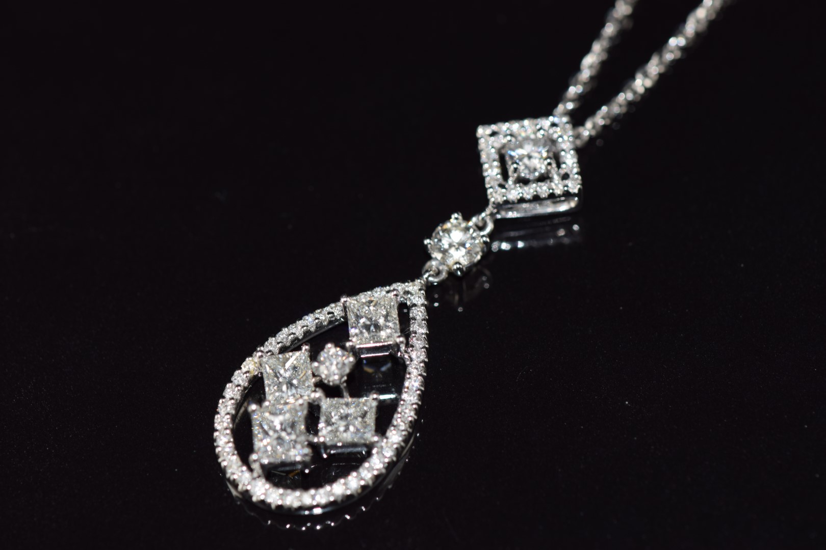 An 18ct white gold pendant set with four princess cut diamonds and further round brilliant cut - Image 2 of 3