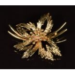 A 9ct gold brooch in the form of a flower with textured surface, 6.2g
