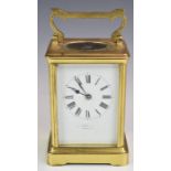 Brass cased carriage clock, with white enamel dial, visible balance wheel to top and striking on a