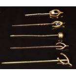 A 9ct gold stick pin in the form of a wishbone set with a sapphire (1.3g), a 9ct gold stick pin in