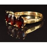 An 18ct gold ring set with four oval cut garnets, 3.6g, size O