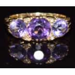 A c1920 18ct gold ring set with three amethysts and four rose cut diamonds, 5.2g, size L