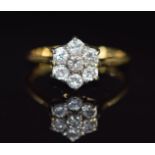 An 18ct gold ring set with seven diamonds in a cluster, each diamond approximately 0.09ct, 3.3g,