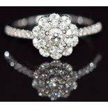 An 18ct white gold ring set with a 0.31ct diamond surrounded by further diamonds, with Tolkowsky