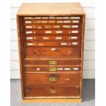 Victorian pine campaign chest of 11 graduated drawers with panelled front door, containing a