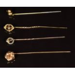 A 9ct gold stick pin in the form of a knot (1g), two stick pins with 15ct gold tops and another