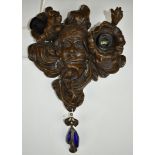 Bronze wall lamp with Art Nouveau style swag and floral decoration beside a lady's face, height