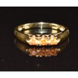 A 9ct gold ring set with three orange sapphires, 2.4g, size N