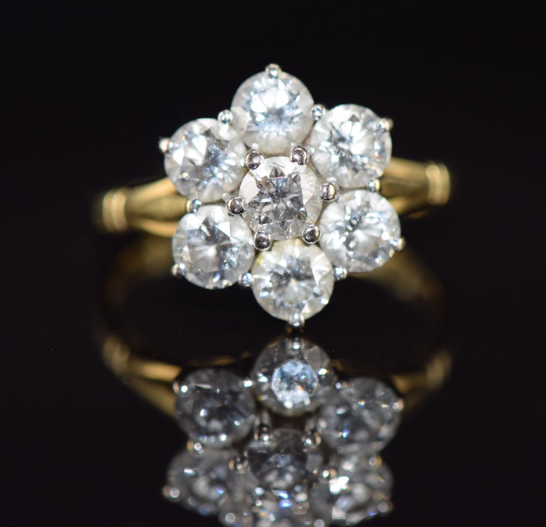 An 18ct gold ring set with seven diamonds, each approximately 0.3ct in a cluster, 4.6g, size O