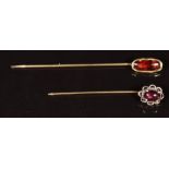 A 14k gold stick pin set with a garnet cabochon (1.9g) and another stick pin set with a garnet